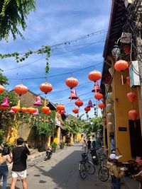 Lanterns hanging over street amidst buildings in city