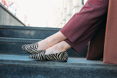 Low section of woman sitting on staircase