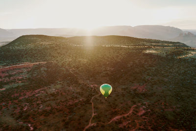 Scenic view of landscape against sky with hot air balloon