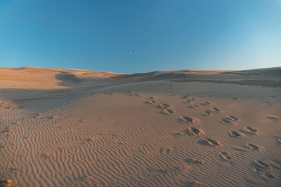 Scenic view of desert against clear blue sky