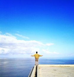 Rear view of man standing at beach