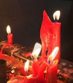 Close-up of lit tea light candles in darkroom
