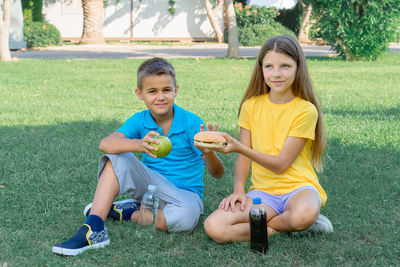 Children schoolchildren eat lunch in the park. harmful and healthy food.