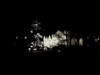 Silhouette buildings against sky at night