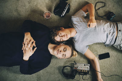 High angle view portrait of friends relaxing on floor at home