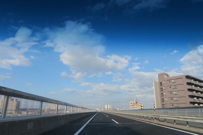 Road amidst buildings against sky