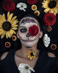 Directly above portrait of woman with halloween make-up lying amidst flowers