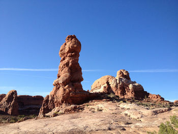 Low angle view of rocky mountains against blue sky