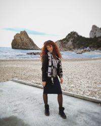 Full length of young woman standing on beach