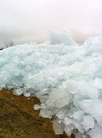 Close-up of frozen water against sky