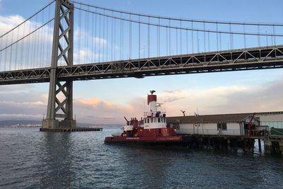 View of suspension bridge against cloudy sky