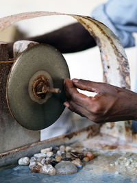 Cropped image of hand working on machine