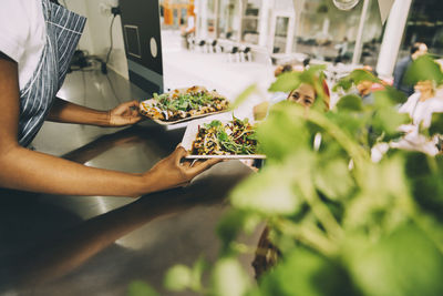 Midsection of man holding food on table