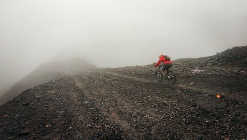 Man on road against sky during foggy weather