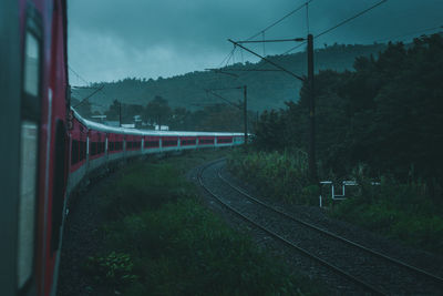 Train by railroad tracks against sky