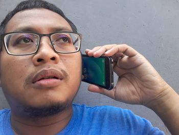 Close-up portrait of young man wearing eyeglasses