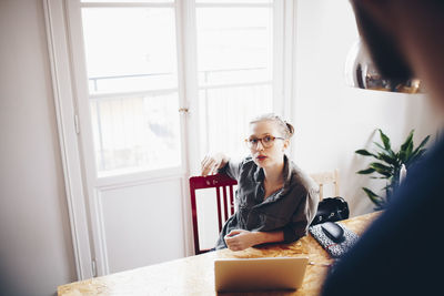 Woman sitting on table at home