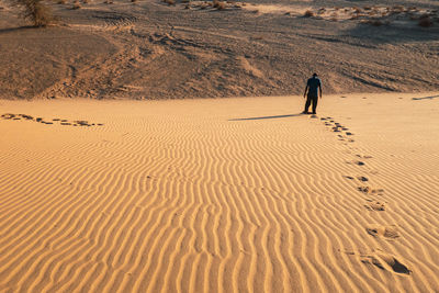 Rear view of a man standing on a sand dune at north horr sand dune, marsabit, kenya