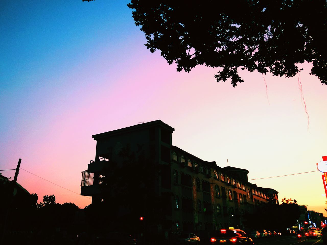 LOW ANGLE VIEW OF SILHOUETTE BUILDINGS AGAINST CLEAR SKY AT SUNSET