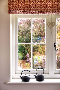 Teapots on window sill at home