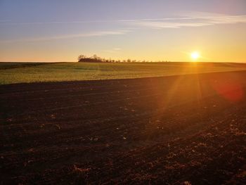 Scenic view of field against sky during sunset