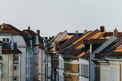 Rooftops with chimneys in city against clear sky
