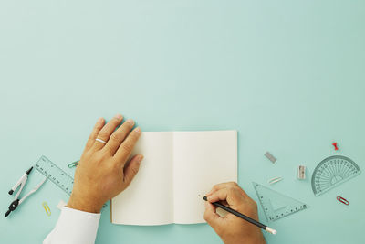 Midsection of person holding paper against white background