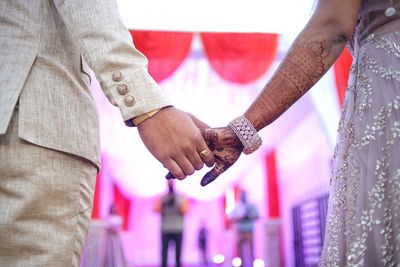 Midsection of couple holding hands