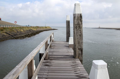 Wooden pier on sea against sky