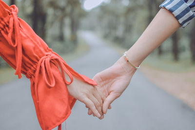 Close-up of hands holding red rose