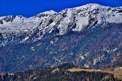 Scenic view of landscape with forests and snowcapped mountains against sky