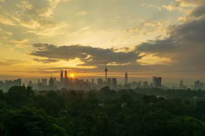 Scenic view of city against sky during sunset