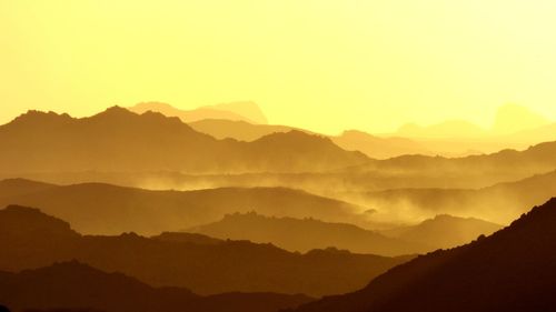 Scenic view of silhouette mountains against sky during sunset