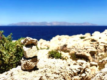 Rocks on beach against sky during sunny day