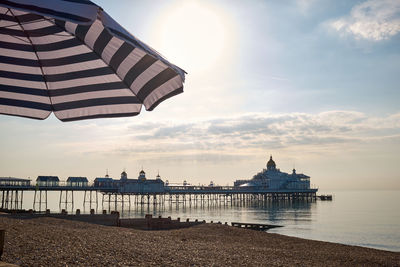 Lifeguard hut on beach against sky during sunset