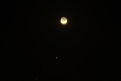 Low angle view of moon against dark sky