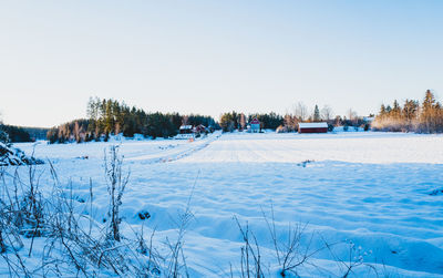 Snow covered landscape against clear sky