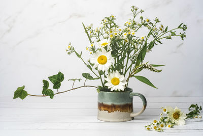 Close-up of yellow flower pot on table