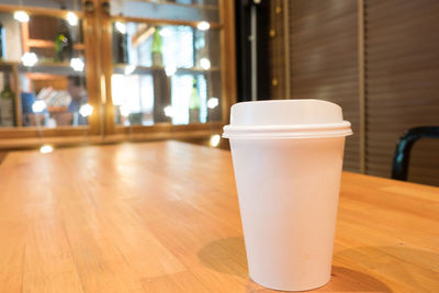 Close-up of disposable coffee cup on table at restaurant