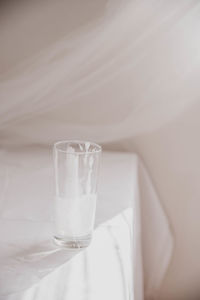 Close-up of drinking glass on bed