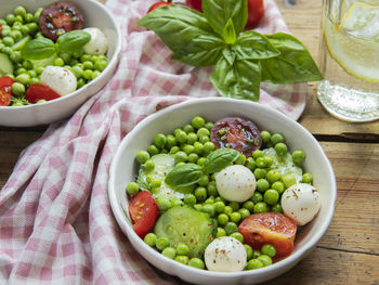 Salad vegetarian. fresh vegetable salad with tomato, cucumber, basil, green peas, mozzarella cheese.