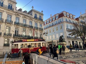 People on street against buildings in city