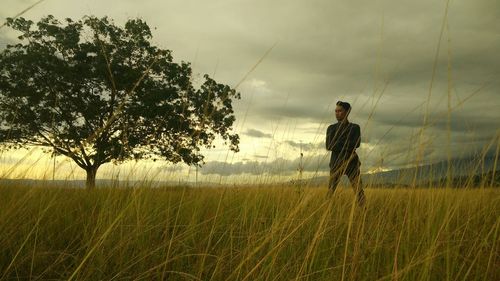 Man standing on field against sky