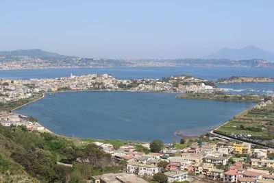 High angle view of townscape by sea against sky