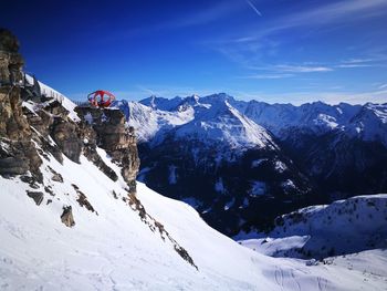 Scenic view of snowcapped mountains against blue sky