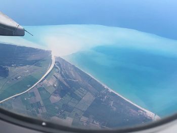 Aerial view of landscape against sky seen from airplane window