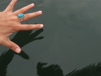 Close-up of hand against lake