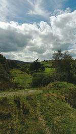 Scenic view of grassy field against cloudy sky