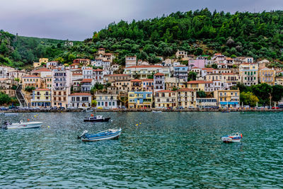 Boats in sea against buildings in city