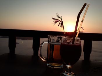 Close-up of beer in glass on table against sky during sunset